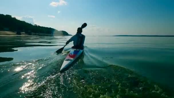 Vue de l'arrière d'un rameur pagayant le long de l'eau — Video