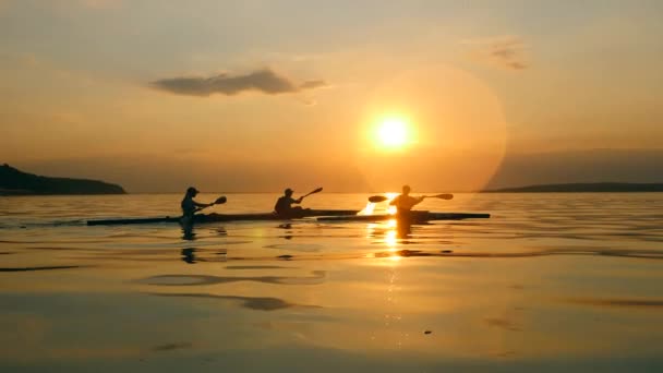 Les plaisanciers font du kayak au coucher du soleil dans une vue latérale — Video