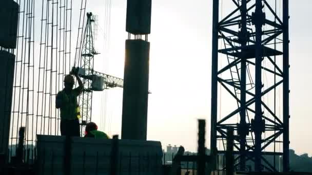 Construtores em uniforme trabalhando no canteiro de obras . — Vídeo de Stock