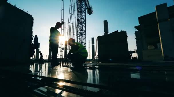 Entrepreneurs en uniforme travaillant sur un chantier . — Video