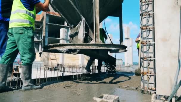Los constructores vierten cemento en un piso en un sitio de construcción . — Vídeos de Stock