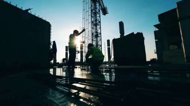 Pessoas com trabalho uniforme num estaleiro de construção . — Vídeo de Stock