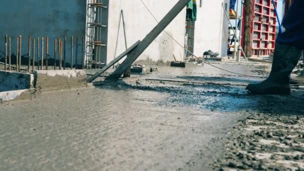 Un trabajador allana el piso de cemento . — Vídeos de Stock