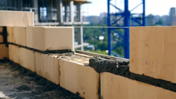 Processo de colocação de tijolos em um canteiro de obras . — Vídeo de Stock
