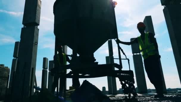 Ingenieurs werken met een machine, gieten cement op een vloer. — Stockvideo