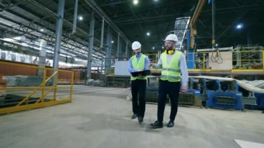 Modern fabrika işçileri bir tesiste yürüyor.