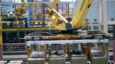 Sarı makine bir tesiste tuğla taşır.