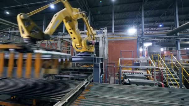 Una máquina mueve ladrillos de una línea de trabajo . — Vídeos de Stock