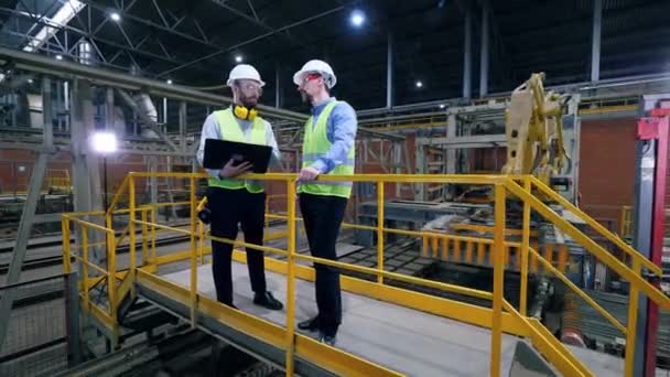 Μηχανικοί, συνάδελφοι εργάζονται σε μια εγκατάσταση σε ένα εργοστάσιο τούβλων. — Αρχείο Βίντεο