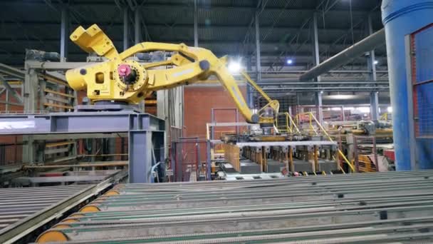 Rameno továrny přesouvá cihly z dopravníku. — Stock video