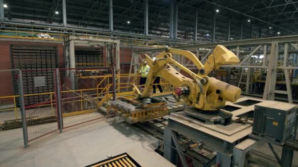 İki adam, mühendisler, teknisyenler, iş arkadaşları bir fabrikada iş makinesini kontrol ediyor.. — Stok video