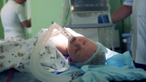 Ένα παιδί υποβάλλεται σε εγχείρηση σε νοσοκομείο, ξαπλωμένος σε χειρουργικό τραπέζι.. — Αρχείο Βίντεο