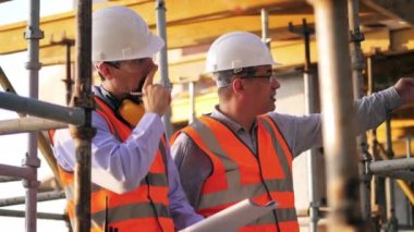 İnşaat mühendisi meslektaşına talimatlar veriyor.