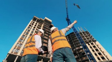 Erkek mimarlar yapım aşamasında ki çok katlı binaları gözlemliyor