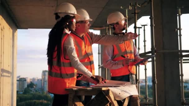 Grupo de arquitectos están hablando en un edificio de gran altura en progreso — Vídeos de Stock