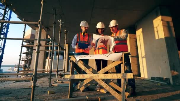 Bauarbeiten im Gange, Ingenieure diskutieren Grundrisse — Stockvideo