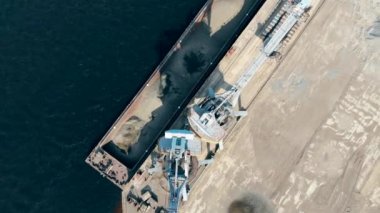 İki yükleyici inşaat malzemelerini mavnadan boşaltMaktadır.