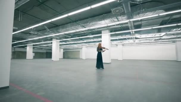 Женщина-музыкант играет на скрипке в пустом зале — стоковое видео