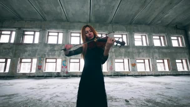 Beautiful woman is playing the violin in an abandoned building — Stock Video