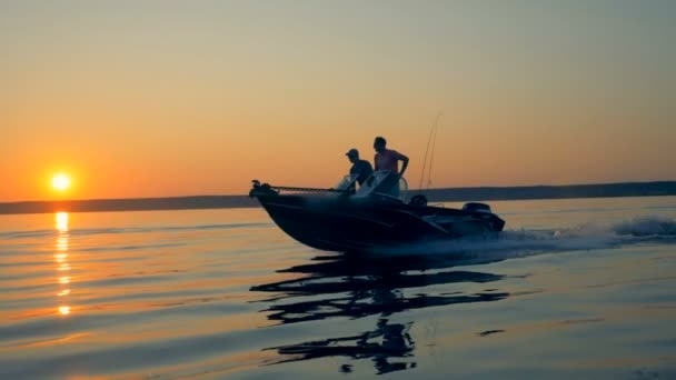 モーターボートを運転する2人の釣り人と日の出の風景。友情、親友の概念. — ストック動画