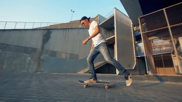 若いアクティブなスポーツマンは、スケートボード、サイドビューにジャンプ. — ストック動画