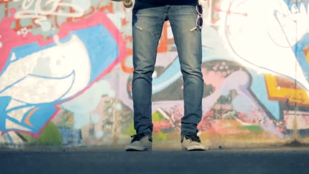 Man daalt zijn skateboard op een weg, close-up. — Stockvideo