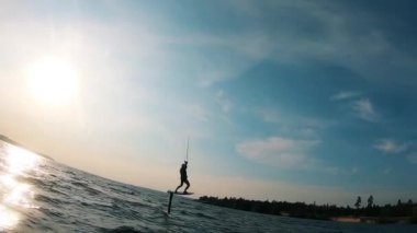 Bir adam kitesurf yaparken tahtadan düşüyor