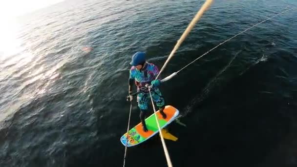 Un hombre está montando un kiteboard a lo largo del río — Vídeos de Stock
