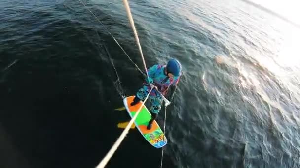 Un hombre en traje de baño está montando un kiteboard — Vídeos de Stock