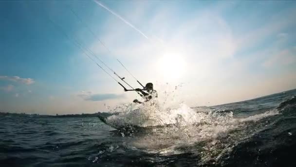 Water is spetteren terwijl een man is kitesurfen — Stockvideo