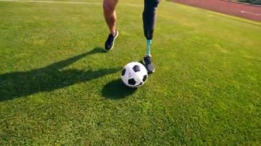 Bir futbol topu protez bacaklı bir adam tarafından damlatılıyor.