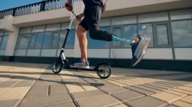 Protez bacaklı atlet scooter kullanıyor