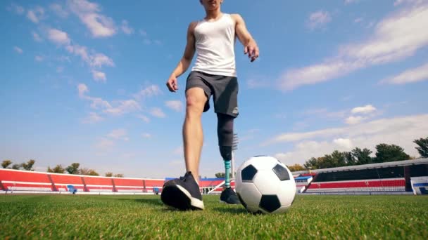 Mannelijke speler met een bionische poot oefent met een bal — Stockvideo