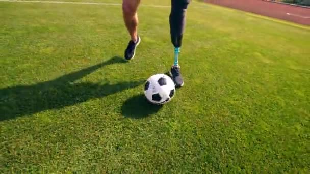 Una pelota de fútbol está siendo regateada por un hombre con una pierna protésica — Vídeos de Stock