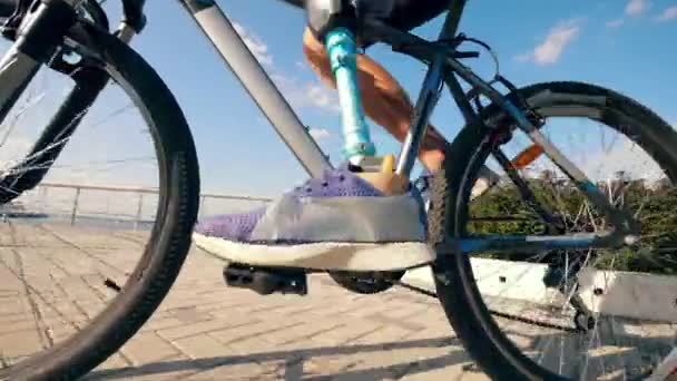 Close-up van fiets pedalen krijgen friste door een man met een bionische poot — Stockvideo