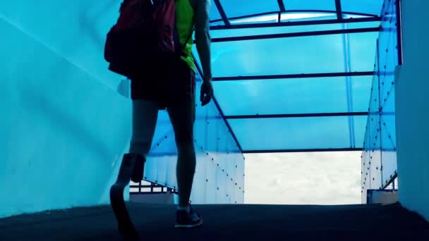 배낭을 들고 걷고 있는 생체공학다리를 가진 스포츠맨 — 비디오