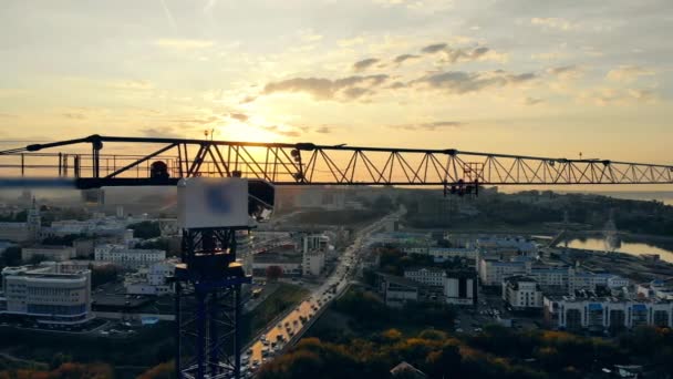 Grue de construction et le paysage urbain du coucher du soleil. Site de construction moderne au coucher du soleil, vue aérienne . — Video