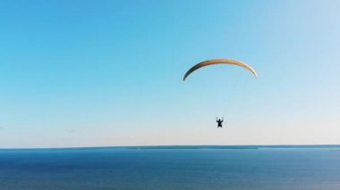 Bir gölün üzerinde planörle uçan sporcu.