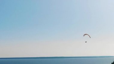 Açık bir gökyüzü arka plan üzerinde bir paraplane ile bir adam.