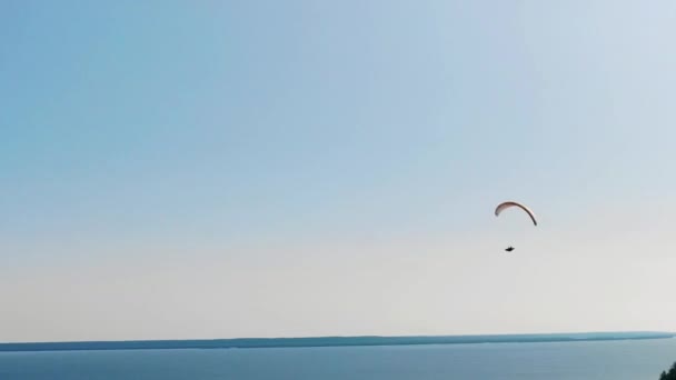 Een man met een paraplane op een heldere hemel achtergrond. — Stockvideo