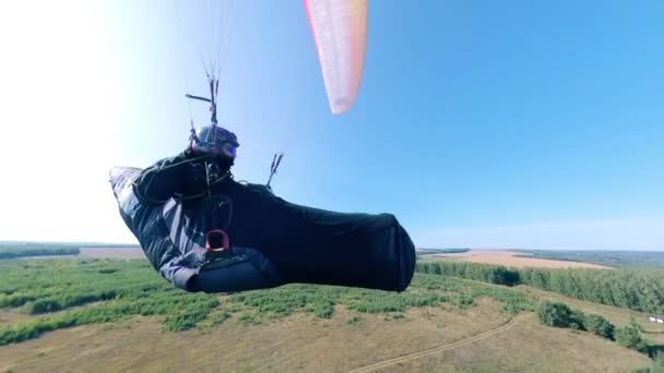 Atleta masculino entrenando con un planeador, volando sobre un campo . — Vídeos de Stock