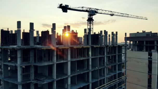Maisons urbaines en cours sur le terrain de construction du coucher du soleil. Vue aérienne du chantier de construction . — Video