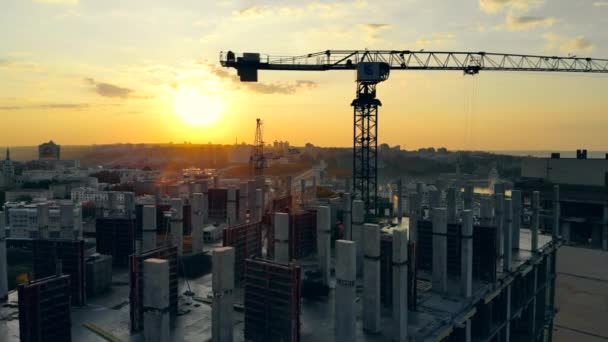 Bouwkavel met machines bij de zonsondergang stadsgezicht — Stockvideo