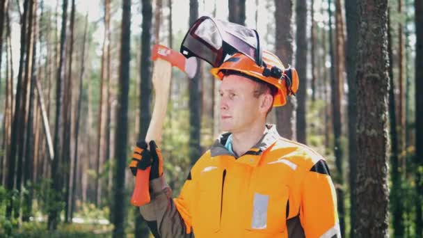 Woodman met een bijl staat tussen de bomen — Stockvideo