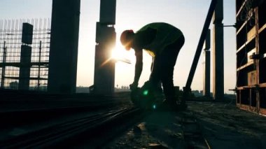 İnşaatçı inşaat alanında çalışırken disk testeresi kullanır.