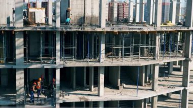 Birçok inşaatçı bir şantiyede çalışıyor. Zaman Uygulaması.