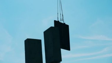 Bir vinç inşaat alanındaki metal blokları hareket ettirir..