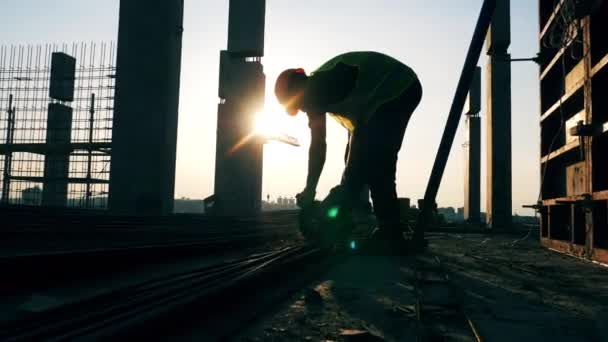 Un constructeur utilise une scie à disque pendant qu'il travaille sur un chantier de construction . — Video