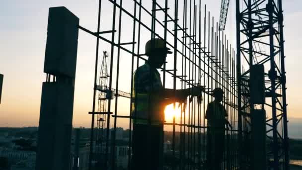 Inżynierowie pracujący z konstrukcją metalową na placu budowy. — Wideo stockowe