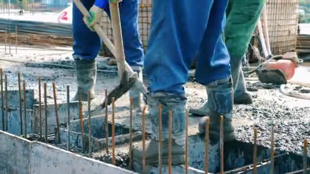 Pracownicy niwelujący beton na podłodze. — Wideo stockowe
